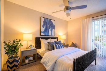 A bedroom with a large bed and a ceiling fan.